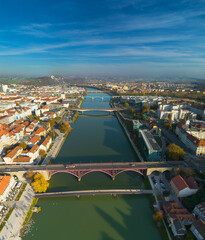 Obraz premium Aerial view of Maribor city with Drava river and multiple bridges, Slovenia. Scenic European cityscape with historic architecture and river flowing through urban landscape.