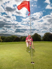 Obraz premium Senior female golfer contemplating shot on golf course green