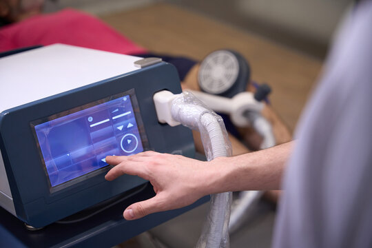 Man using therapeutic device with touchscreen in rehabilitation center