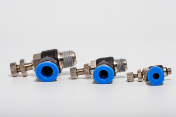 Pneumatic speed control fittings with blue push-to-connect rings and adjustable needles for precise...