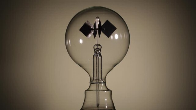 Center align, rotating Crookes radiometer light mill on bright white background. Soft glow start, High-key lighting, minimalist science experiment, solar vane, physics education, left-right copy space