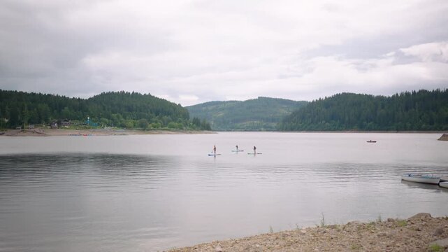 Schluchsee Schwarzwald Black Forest Germany with three people on stand up paddles