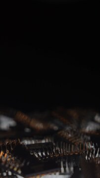 Macro of TTL integrated circuits rotating on turntable, side view, yellow keylight, cold backlight, bokeh and shallow DOF. Black copy space on top third for text or graphic elements