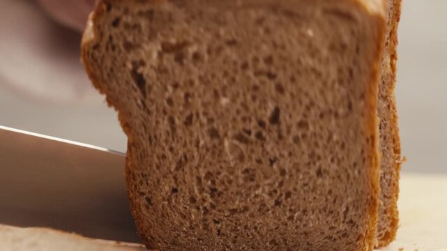 Black rye bread close up, dark brown sliced loaf, borodinsky slavic food, square slices with coriander on white background