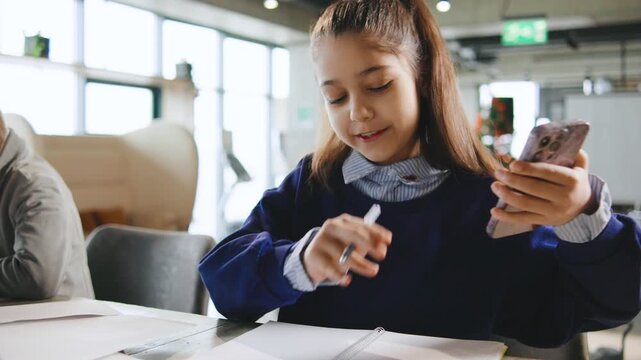 Schoolchildren are writing notes at a school activity in a classroom setting during the daytime with natural light