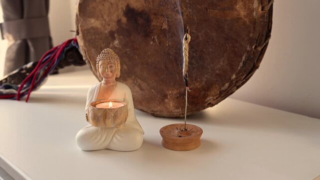 statue with burning candle and smoking incense