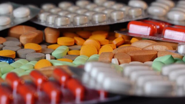 Side view of rotating medical pills and blister packs with beautiful bokeh and shallow DOF. Macro shot of pharmaceutical tablets on turntable ver 2