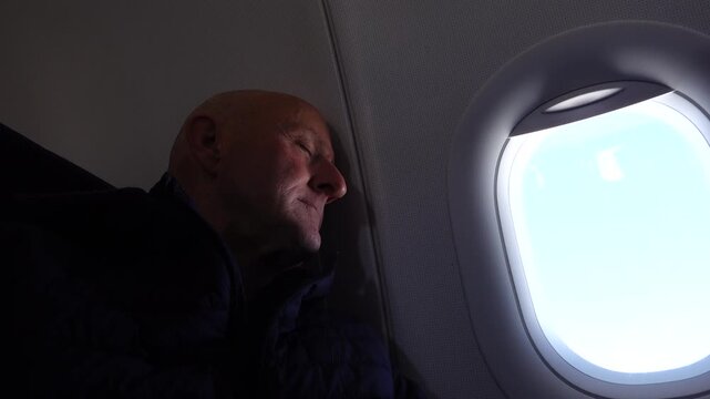 Stockholm, Sweden A man sleeping on a passenger airplane against the bulkhead,. 
