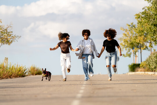 Friends joyfully running outdoors in the sunshine