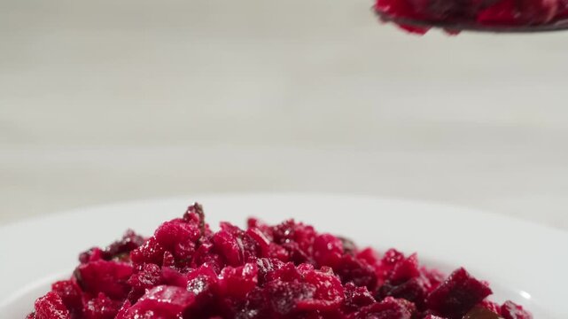 Russian beetroot vinaigrette salad with green peas, boiled vegetables and dill, close up in restaurant. 