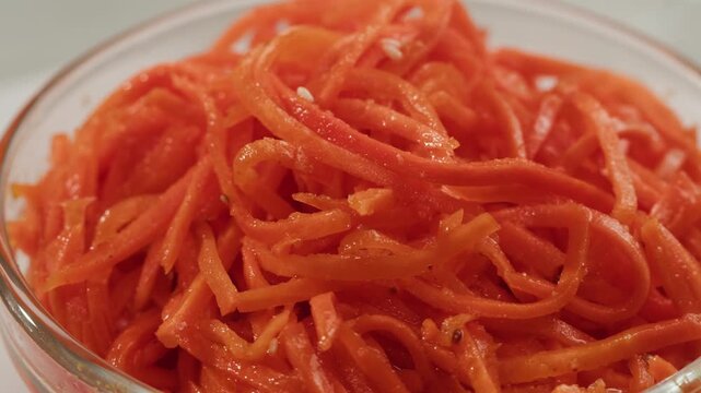 Fermented marinated carrot salad, Korean style chopped carrots, garlic, vegetable oil and seasonings on a turntable