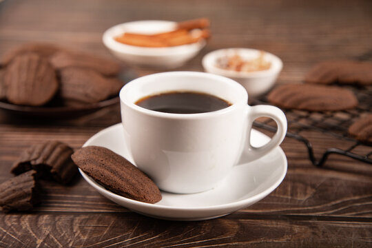 Coffee with chocolate madeleines on rustic table