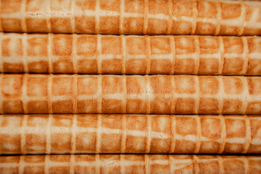 Close-up of baked waffle tubes in a neat stack