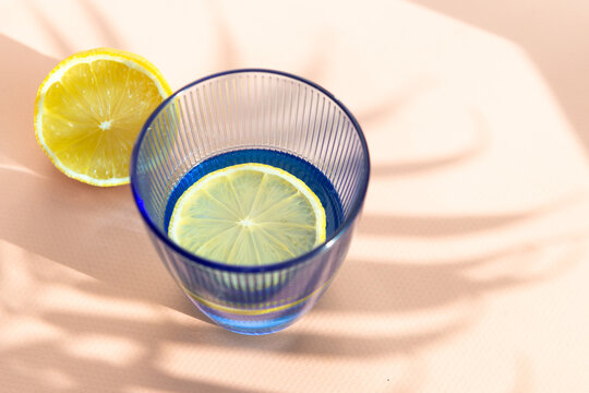 Fresh lemon slice in clear blue glass of water