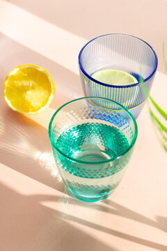 Refreshing glasses of water with lemon slice and sunlight