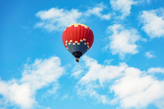Red hot air balloon against a clear blue sky