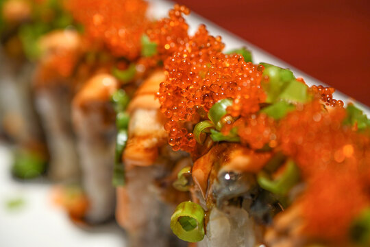 Sushi Roll Topped with Tobiko Fish Roe, Shrimp, and Scallions, Japanese Restaurant Close Up