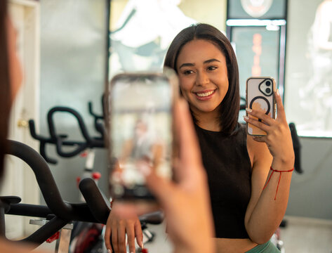 Fitness enthusiast capturing gym moments with a smile
