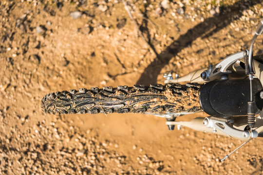 Close-up of a muddy mountain bike tire on a dirt path