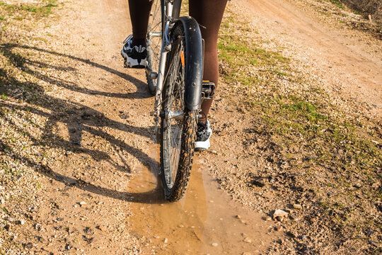 Mountain biker navigates muddy terrain on sunny day
