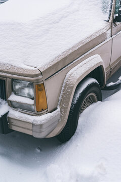 Snow-covered vehicle on urban street in winter