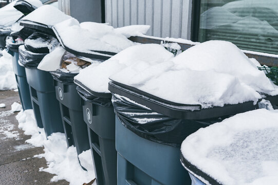 Snow-covered trash bins after heavy urban snowfall