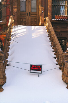 Snow-covered urban steps with private property sign