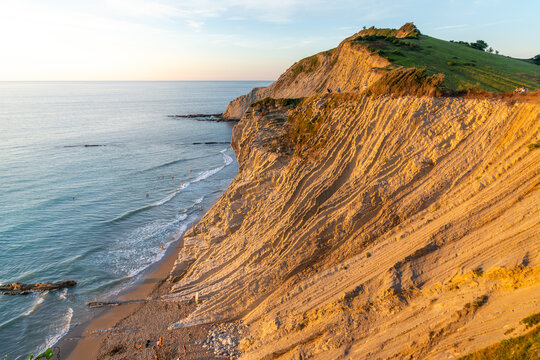 Coastal cliffs meeting the ocean at sunset