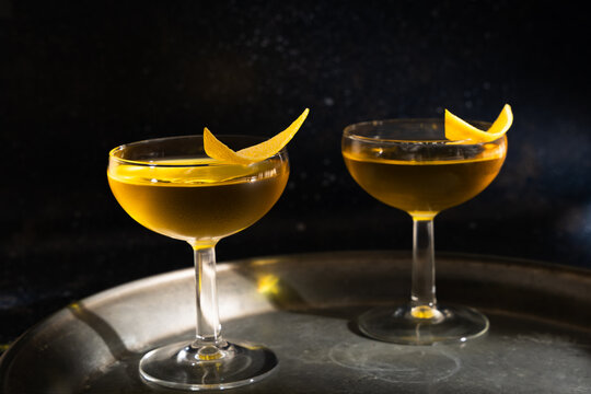 Crystal glasses with golden herbal liqueur and garnish