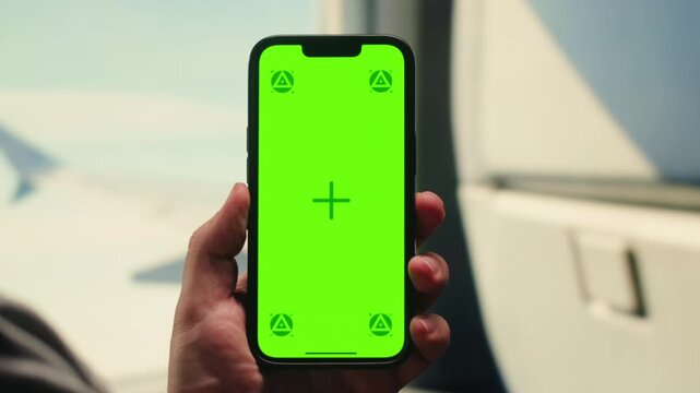 Man tourist using smartphone with green screen while traveling by train or bus, travelling application, male working during business travel. 