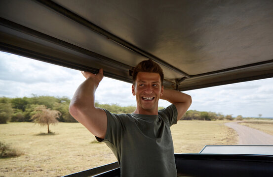 Smiling tourist enjoying safari in african savannah