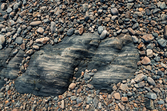 Smooth pebbles on a textured rocky shore