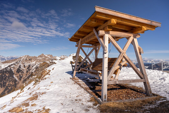 Wooden bench overlooking snowy Alps in January
