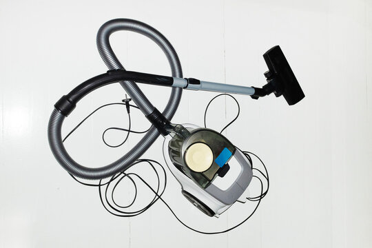 Modern vacuum cleaner on white wooden floor