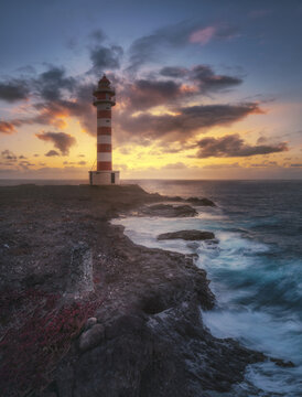 Punta Sardina Lighthouse at sunset with dramatic sky