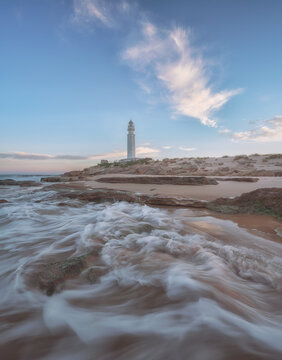Serene lighthouse by the ocean during sunset