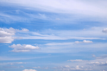 Naklejka premium Blue sky with scattered clouds, subtle blue gradients, and soft cloud formations. Space for text. Not AI.