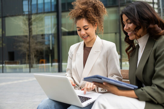 Women collaborating on a business project outdoors