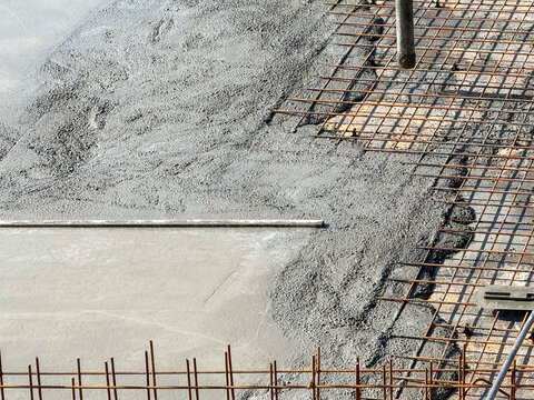 Concrete pouring over steel mesh in construction site