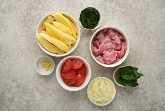 Vegetables and meat ready for cooking in a home kitchen in the afternoon with various ingredients placed in bowls