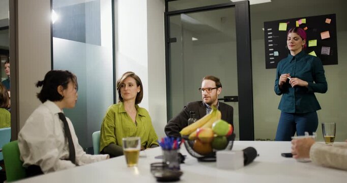 Business team holds meeting in office to discuss plans and strategies with a mix of men and women in a modern setting