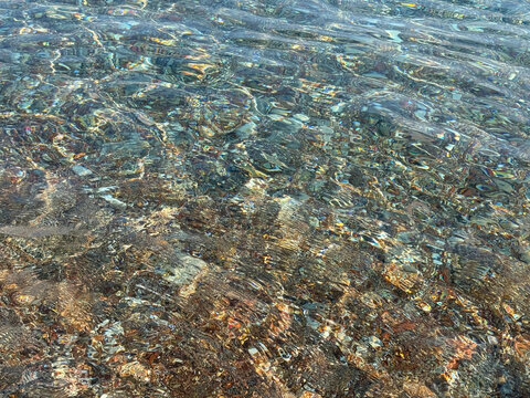 Sea water with pebbles background. 
