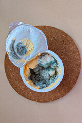 Moldy leftovers in plastic container with lifted lid and damaged seal, spoiled texture and unpleasant mood