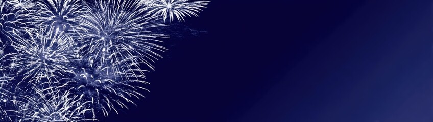 Naklejka premium Fireworks display against dark night sky sparkling explosions celebration