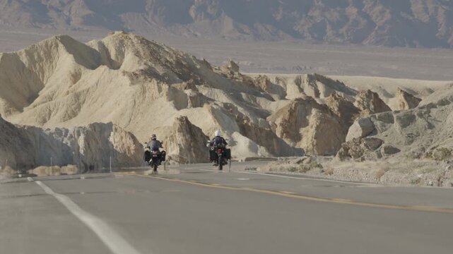 Two adventure motorcyclists ride near Zabriskie Point in Death Valley, CA