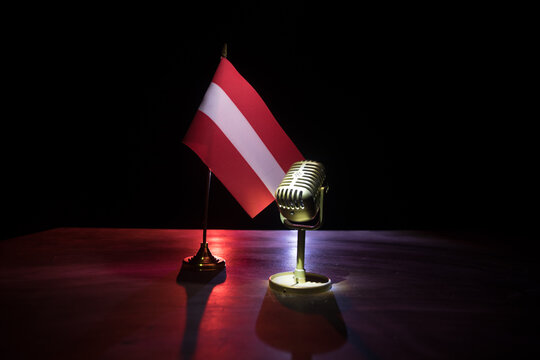 Microphone on a background of a blurry flag of Austria close-up. dark table decoration