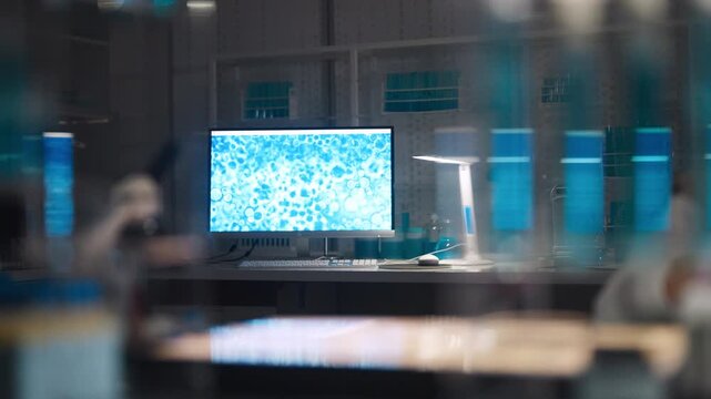 Female scientist in protective gear working in a modern laboratory to test DNA. Looking into the microscope to examine the sample. Selective focus