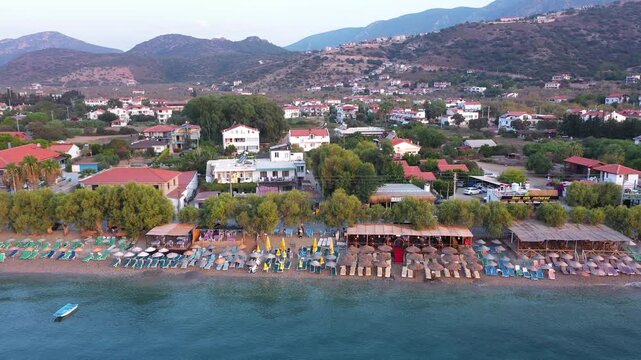 Aerial view of beach coastline. Looking from sea over beach to village of Palamutb&uuml;k&uuml;. Hotels, hostels and holiday camping areas can be seen among the almond trees. Dat&ccedil;a, Muğla, Turkey