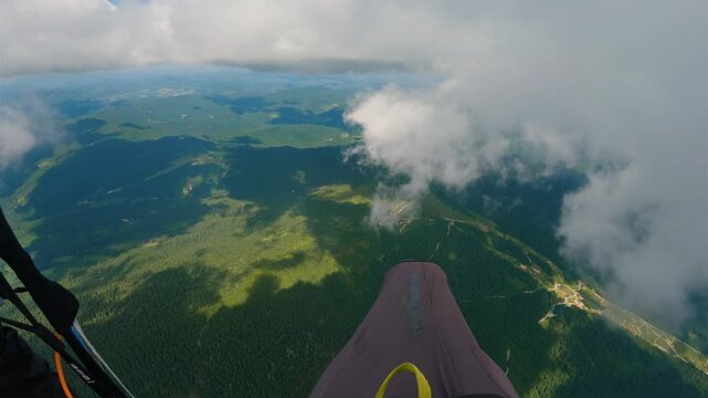 POV Paragliding Flight Above Clouds and Green Forest Mountains