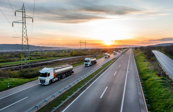 Convoy or Fleet of Tank trucks with oil or gas on a Highway through the rural landscape